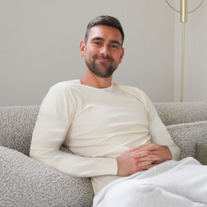 A man wearing a long sleeve Thermo Fleece Sensitive white Merino t shirt